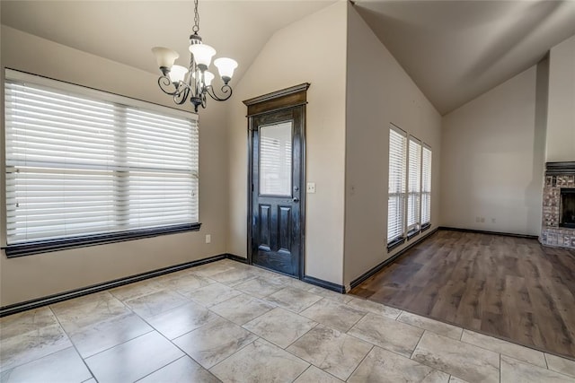 3904 Normandy Rd, Edmond, OK 73013 - entrance foyer with lofted ceiling, a chandelier, and a brick fireplace