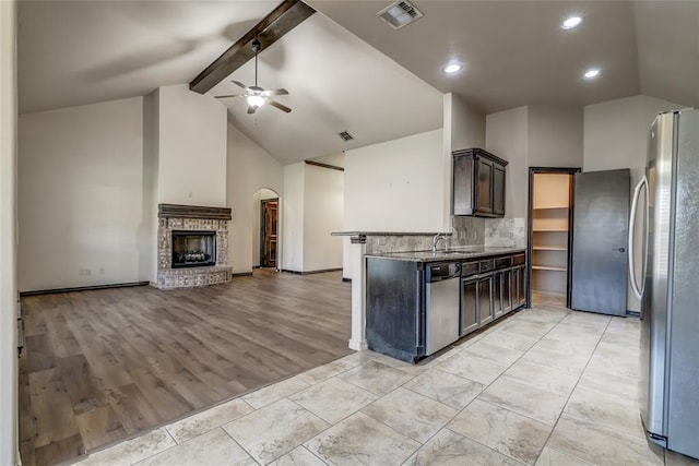 3904 Normandy Rd, Edmond, OK 73013 - kitchen featuring appliances with stainless steel finishes, ceiling fan, open floor plan, beam ceiling, and high vaulted ceiling