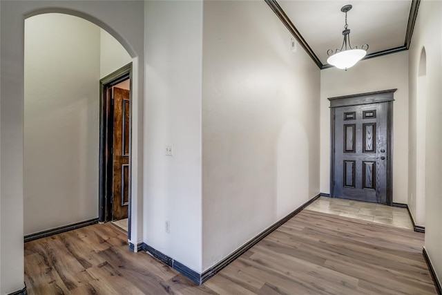 3904 Normandy Rd, Edmond, OK 73013 - entrance foyer with arched walkways, light wood-style floors, and crown molding