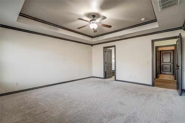 3904 Normandy Rd, Edmond, OK 73013 - empty room featuring a raised ceiling, light carpet, ceiling fan, and crown molding
