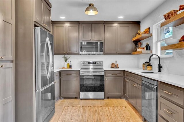 14500 Williams Way, Luther, OK 73054 - kitchen featuring appliances with stainless steel finishes, light wood-type flooring, decorative backsplash, light countertops, and open shelves