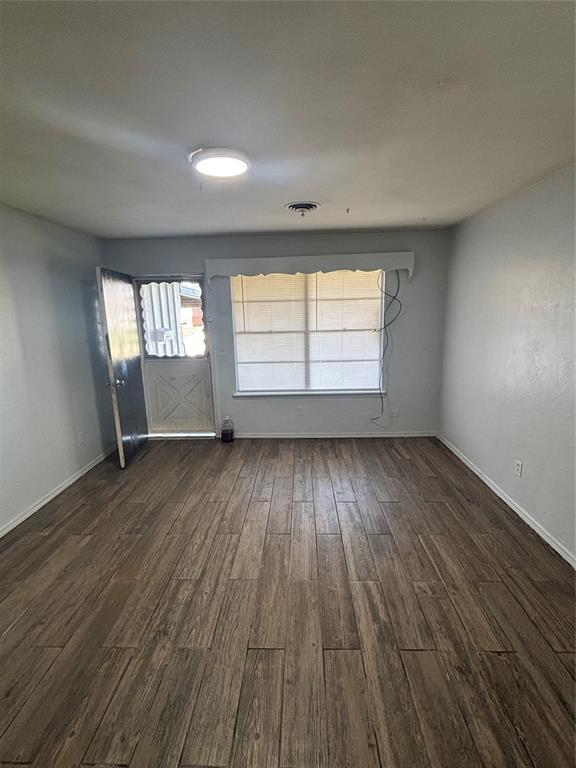833 S Scott St, Del City, OK 73115 - empty room featuring dark wood-style floors and baseboards