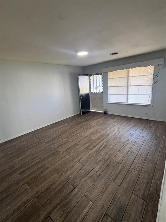 833 S Scott St, Del City, OK 73115 - spare room featuring dark wood-style flooring and baseboards