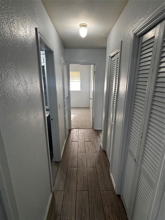 833 S Scott St, Del City, OK 73115 - hallway with dark wood-style floors, a textured ceiling, and a textured wall