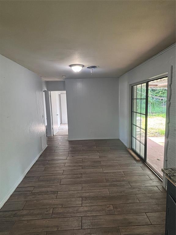833 S Scott St, Del City, OK 73115 - empty room with dark wood-type flooring