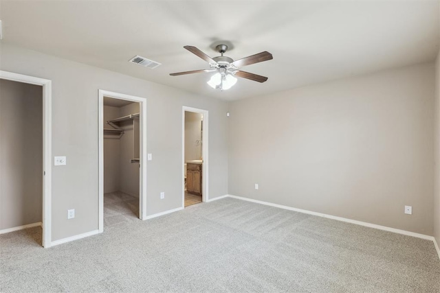 2718 Sharpish Way, Norman, OK 73069 - unfurnished bedroom featuring a walk in closet, light colored carpet, a closet, ceiling fan, and ensuite bath