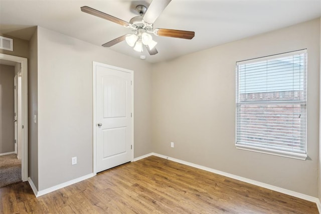 2718 Sharpish Way, Norman, OK 73069 - unfurnished bedroom featuring multiple windows, light wood finished floors, and ceiling fan