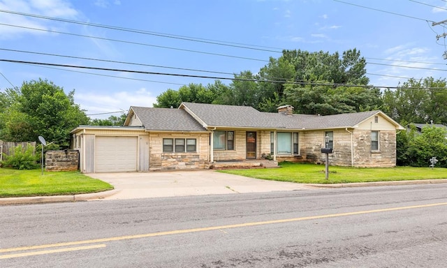 3409 S 4th St, Chickasha, OK 73018 - view of front of home featuring stone siding, an attached garage, concrete driveway, a chimney, and roof with shingles