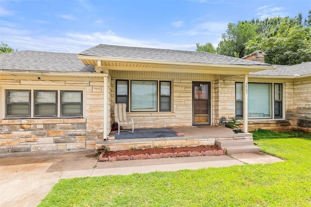 3409 S 4th St, Chickasha, OK 73018 - view of front of home featuring a porch, stone siding, a front yard, a shingled roof, and a chimney