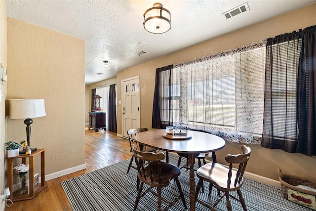 3409 S 4th St, Chickasha, OK 73018 - dining area with a textured ceiling, light wood-style flooring, and a textured wall