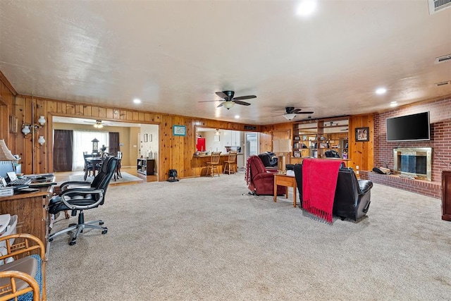 3409 S 4th St, Chickasha, OK 73018 - carpeted living area with an office area, wooden walls, a ceiling fan, a brick fireplace, and recessed lighting