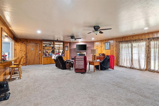 3409 S 4th St, Chickasha, OK 73018 - living area featuring light colored carpet, a ceiling fan, a brick fireplace, wooden walls, and recessed lighting