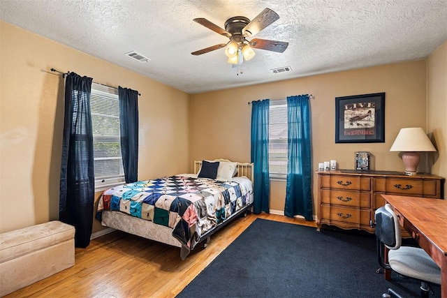 3409 S 4th St, Chickasha, OK 73018 - bedroom featuring wood finished floors, a textured ceiling, a ceiling fan, and an office area