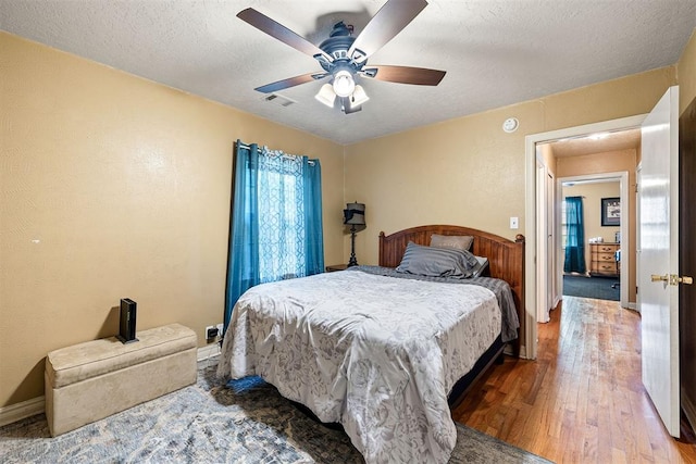 3409 S 4th St, Chickasha, OK 73018 - bedroom with wood finished floors, ceiling fan, and a textured ceiling