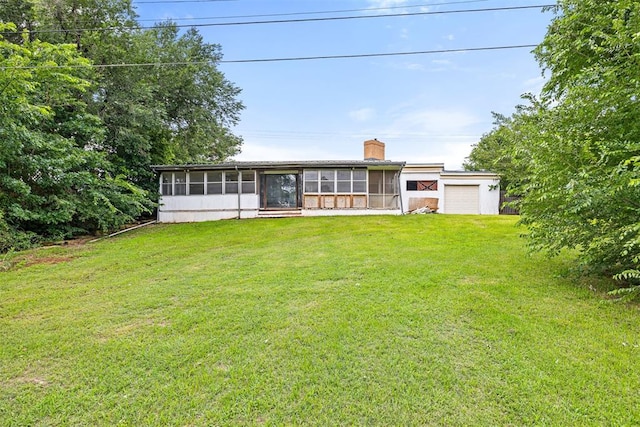 3409 S 4th St, Chickasha, OK 73018 - view of front of property featuring a sunroom, a chimney, a front lawn, and an attached garage