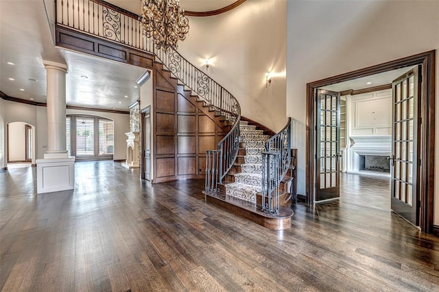 6516 NW Grand Blvd, Nichols Hills, OK 73116 - stairs with arched walkways, decorative columns, crown molding, french doors, and wood finished floors