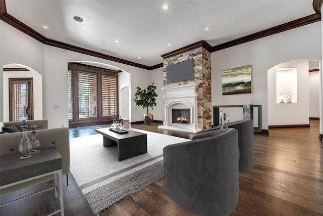 6516 NW Grand Blvd, Nichols Hills, OK 73116 - living area featuring ornamental molding, arched walkways, dark wood finished floors, a fireplace, and recessed lighting