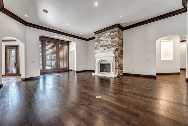 6516 NW Grand Blvd, Nichols Hills, OK 73116 - unfurnished living room featuring crown molding, wood finished floors, arched walkways, a fireplace, and recessed lighting