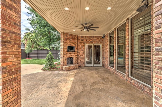 6516 NW Grand Blvd, Nichols Hills, OK 73116 - fenced backyard featuring an outdoor brick fireplace, a patio area, and a ceiling fan