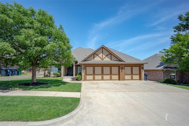 16312 Old Elm Ln, Edmond, OK 73013 - english style home with an attached garage, concrete driveway, and a front yard