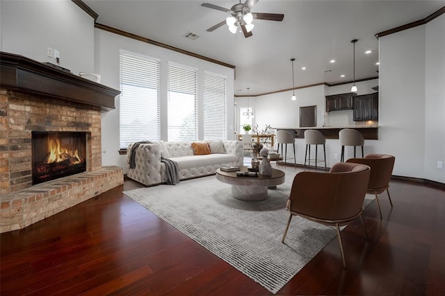 16312 Old Elm Ln, Edmond, OK 73013 - living room with ornamental molding, ceiling fan, a brick fireplace, dark wood finished floors, and recessed lighting