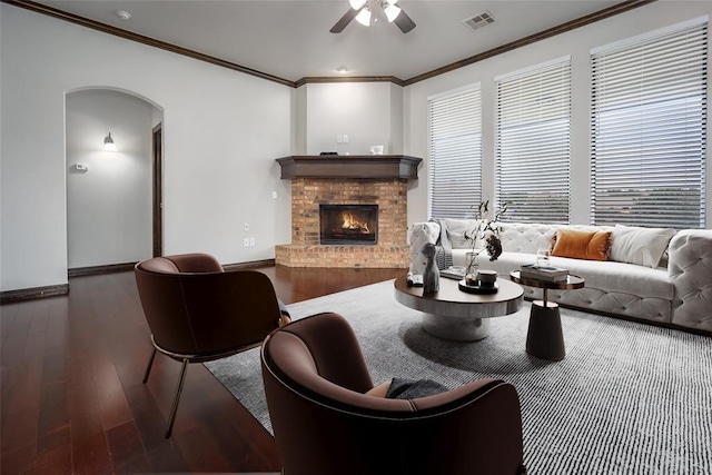 16312 Old Elm Ln, Edmond, OK 73013 - living area featuring ceiling fan, crown molding, wood finished floors, a brick fireplace, and arched walkways