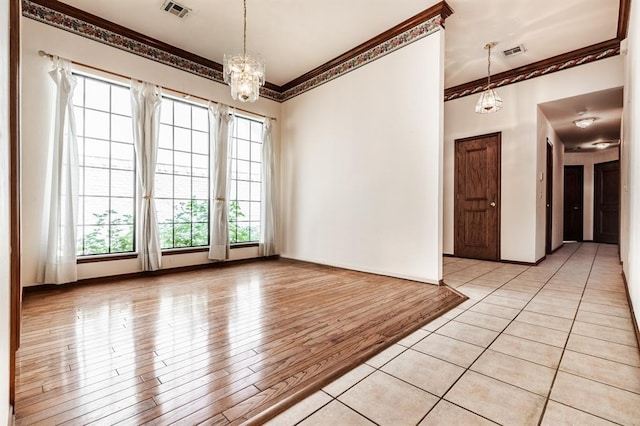 11129 Springhollow Ct, Oklahoma City, OK 73120 - empty room featuring a chandelier, crown molding, and light wood-type flooring