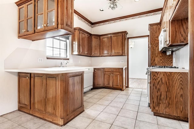 11129 Springhollow Ct, Oklahoma City, OK 73120 - kitchen featuring brown cabinetry, light tile patterned flooring, a peninsula, glass insert cabinets, and white appliances