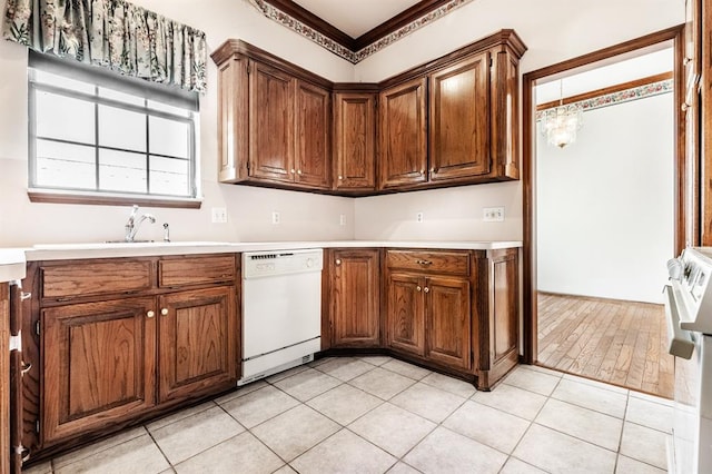 11129 Springhollow Ct, Oklahoma City, OK 73120 - kitchen featuring dishwasher, light countertops, light tile patterned flooring, and brown cabinetry