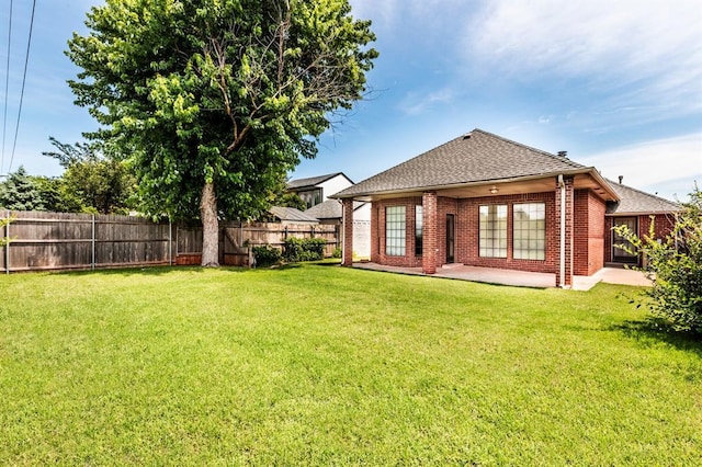 11129 Springhollow Ct, Oklahoma City, OK 73120 - back of house with roof with shingles, a fenced backyard, brick siding, and a patio area