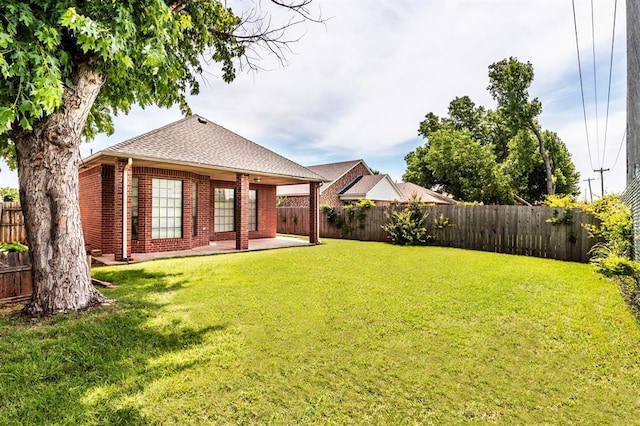 11129 Springhollow Ct, Oklahoma City, OK 73120 - back of house with brick siding, a fenced backyard, a patio, and a shingled roof