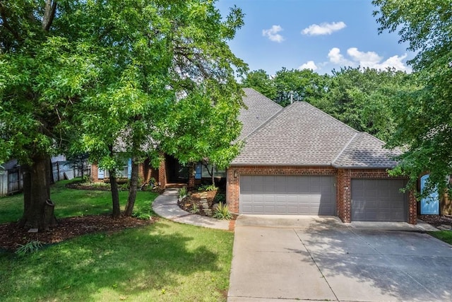 108 N Bradbury Dr, Edmond, OK 73034 - view of front facade with a garage, a front yard, brick siding, driveway, and a shingled roof