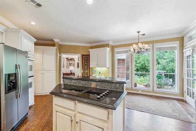 108 N Bradbury Dr, Edmond, OK 73034 - kitchen with stainless steel refrigerator with ice dispenser, black electric stovetop, dark countertops, a chandelier, and dark wood-type flooring