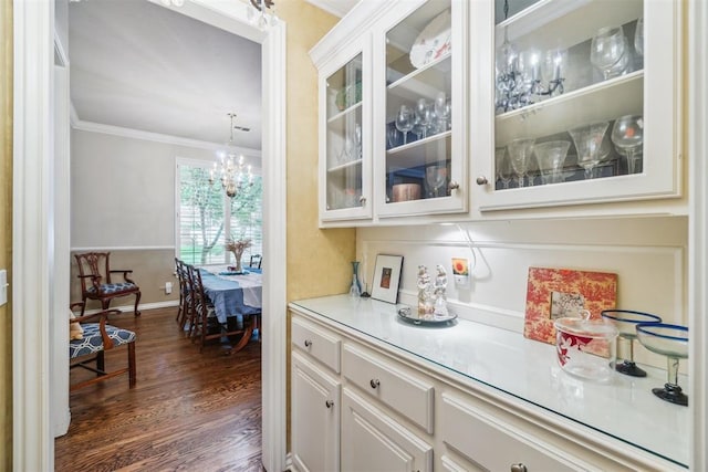 108 N Bradbury Dr, Edmond, OK 73034 - bar featuring ornamental molding, dark wood-style floors, and a chandelier