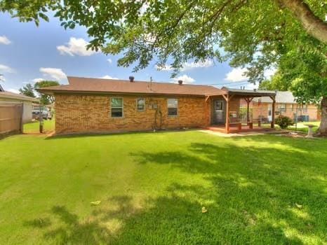 1329 SW 77th Ter, Oklahoma City, OK 73159 - back of house featuring a lawn and a patio area