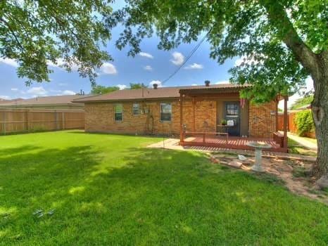1329 SW 77th Ter, Oklahoma City, OK 73159 - back of house with a fenced backyard and a wooden deck