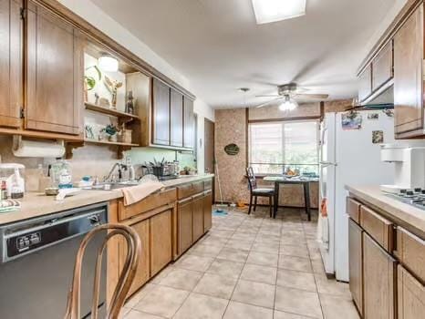 1329 SW 77th Ter, Oklahoma City, OK 73159 - kitchen featuring dishwasher, a ceiling fan, light countertops, and light tile patterned floors