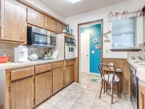 1329 SW 77th Ter, Oklahoma City, OK 73159 - kitchen featuring stainless steel appliances, light countertops, and light tile patterned flooring