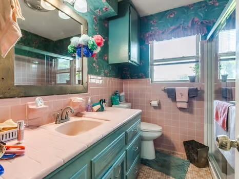1329 SW 77th Ter, Oklahoma City, OK 73159 - bathroom featuring a stall shower, vanity, plenty of natural light, tile walls, and wallpapered walls