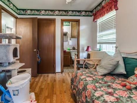 1329 SW 77th Ter, Oklahoma City, OK 73159 - bedroom with light wood finished floors and ensuite bath