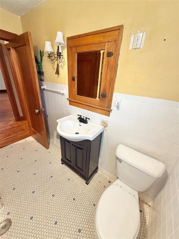 722 E Main St, Sentinel, OK 73664 - bathroom featuring tile walls, vanity, and wainscoting