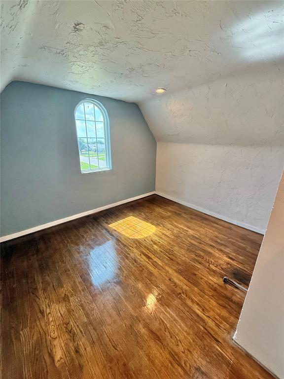 722 E Main St, Sentinel, OK 73664 - additional living space featuring vaulted ceiling and hardwood / wood-style floors