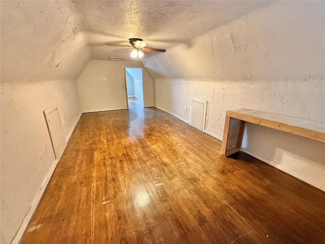 722 E Main St, Sentinel, OK 73664 - additional living space featuring a textured ceiling, a textured wall, wood finished floors, a ceiling fan, and vaulted ceiling