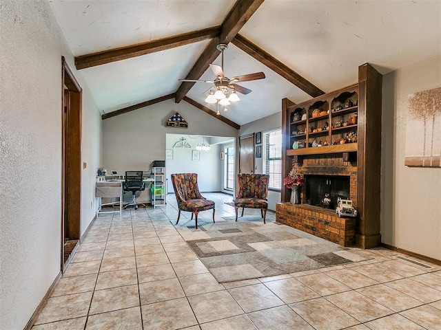 2228 Butternut Pl, Edmond, OK 73013 - living area with a desk, a textured wall, ceiling fan, light tile patterned floors, and a brick fireplace