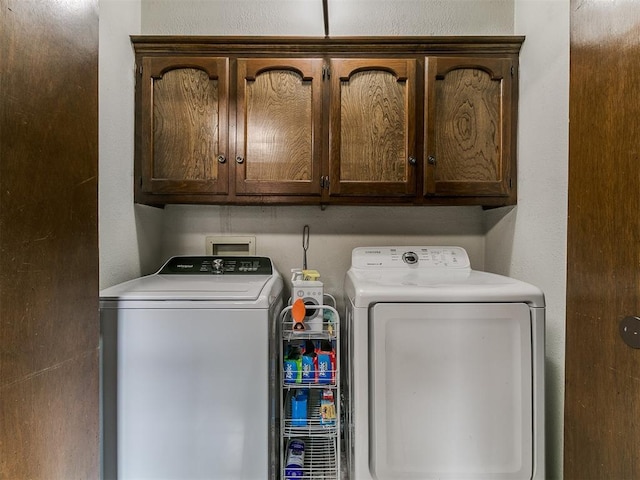 2228 Butternut Pl, Edmond, OK 73013 - laundry area featuring independent washer and dryer, cabinet space, and a textured wall