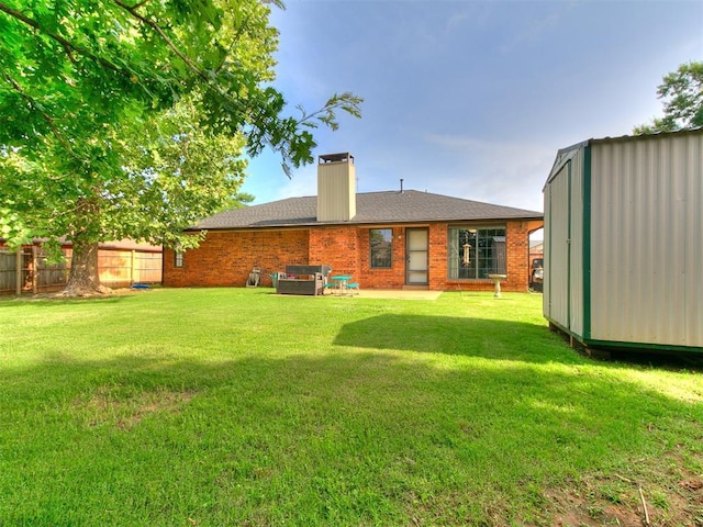 2228 Butternut Pl, Edmond, OK 73013 - rear view of property with a chimney, brick siding, and a storage shed