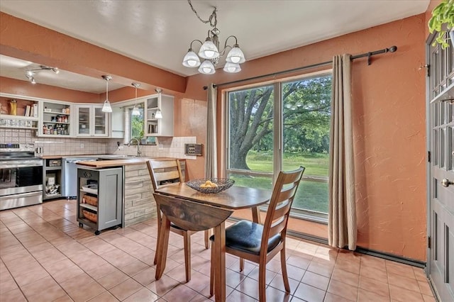 2122 Edinburg Dr, Yukon, OK 73099 - dining space featuring plenty of natural light, a chandelier, a textured wall, and light tile patterned floors