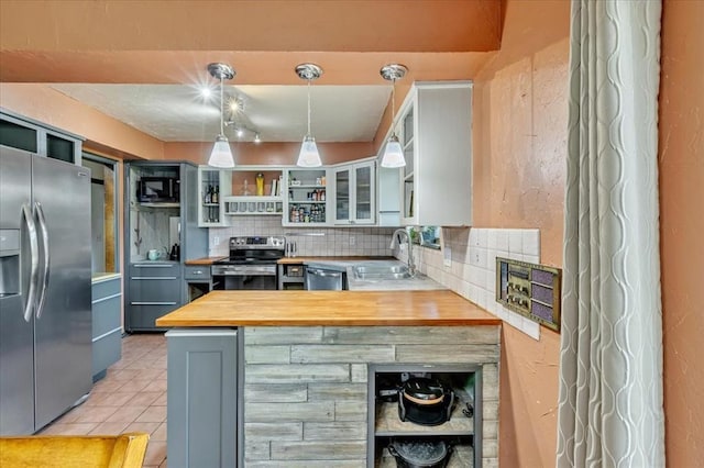 2122 Edinburg Dr, Yukon, OK 73099 - kitchen with appliances with stainless steel finishes, open shelves, wooden counters, backsplash, and a peninsula