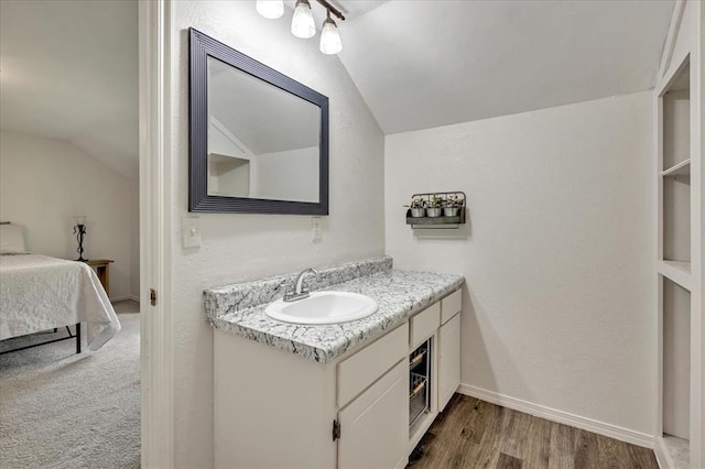 2122 Edinburg Dr, Yukon, OK 73099 - bathroom featuring vaulted ceiling, vanity, connected bathroom, and wood finished floors