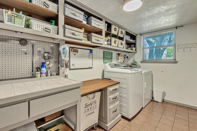 2122 Edinburg Dr, Yukon, OK 73099 - laundry room featuring light tile patterned flooring, washer and clothes dryer, and a textured ceiling